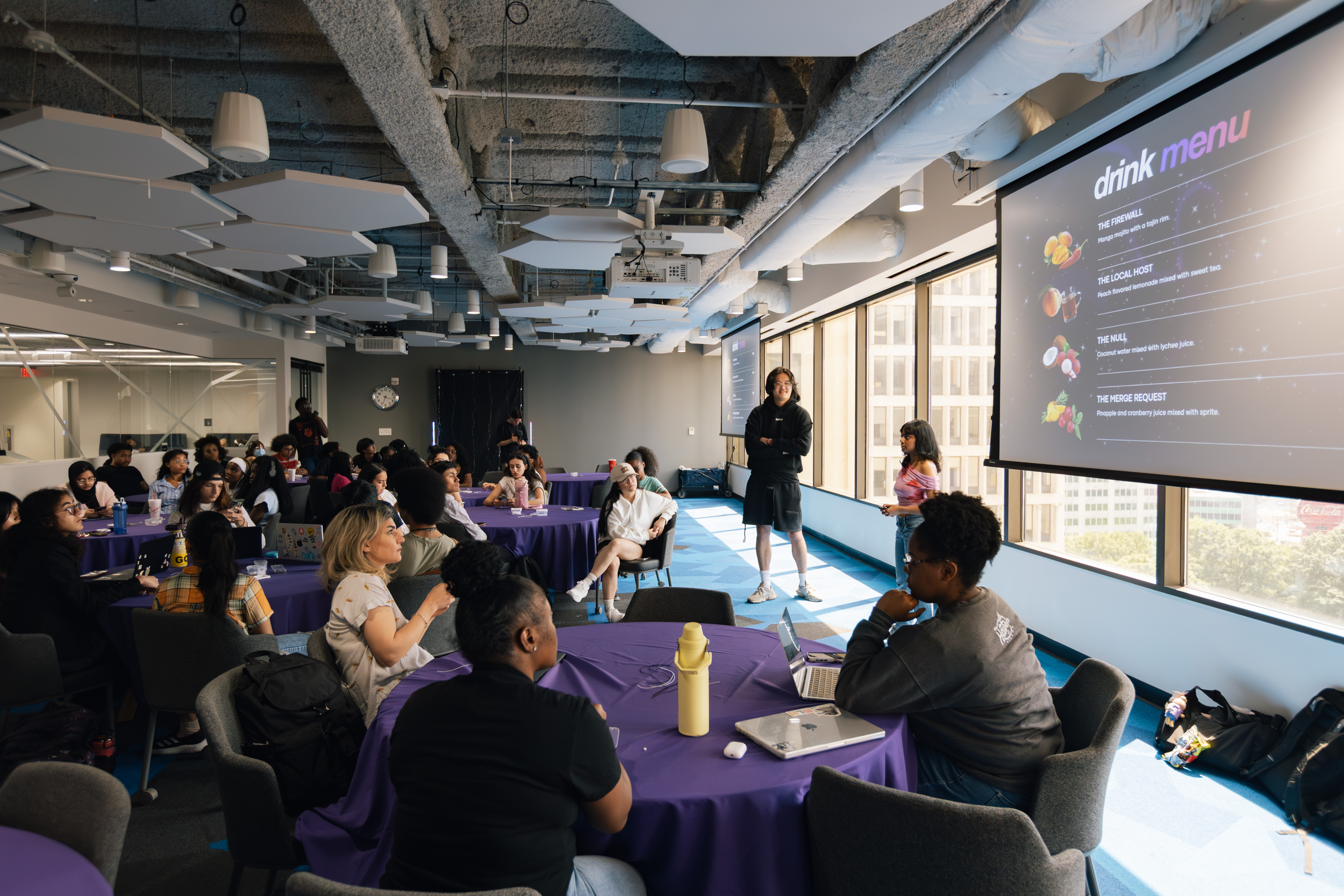 progirls members listening to a presentation at an event